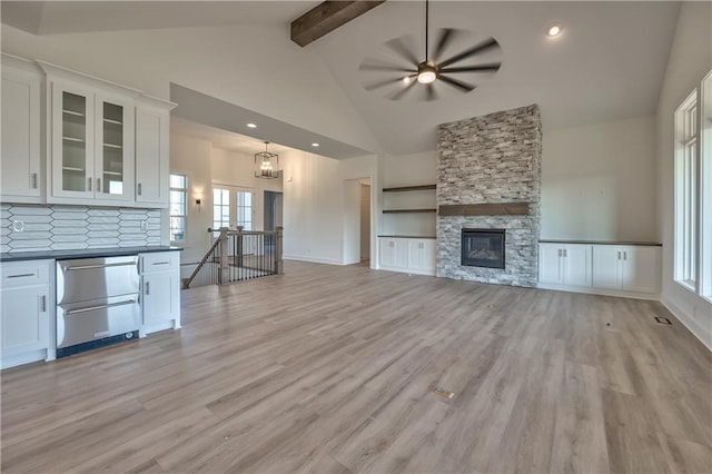 unfurnished living room featuring a fireplace, light wood-type flooring, and a healthy amount of sunlight