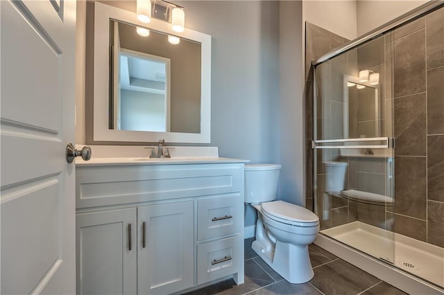 bathroom with tile patterned floors, a shower with door, vanity, and toilet