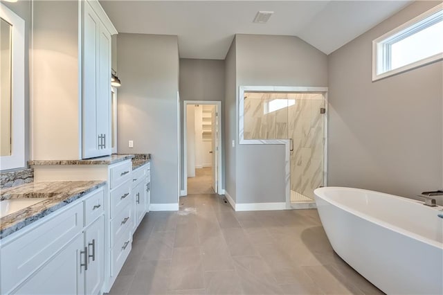 bathroom with vaulted ceiling, independent shower and bath, vanity, and tile patterned floors