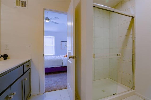 bathroom featuring a shower with shower door, vanity, ceiling fan, and tile patterned floors