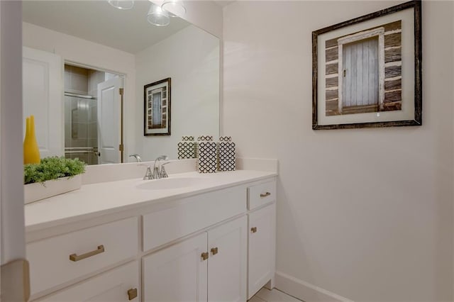 bathroom featuring a shower with shower door and vanity