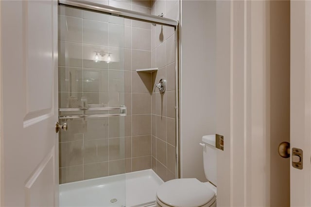 bathroom with toilet and an enclosed shower