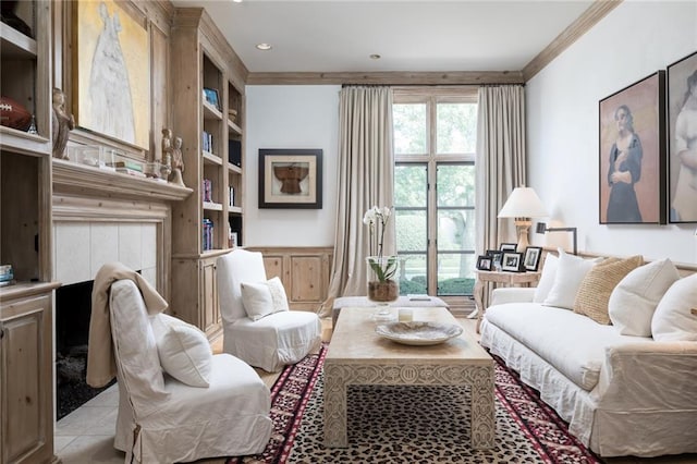 living area featuring built in shelves, a tile fireplace, ornamental molding, and light tile flooring