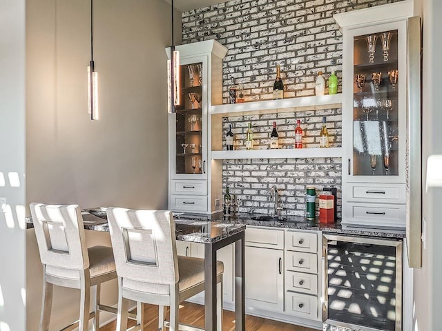 2908 NE 102nd St, Kansas City, MO 64155 - bar with white cabinetry, brick wall, sink, and beverage cooler
