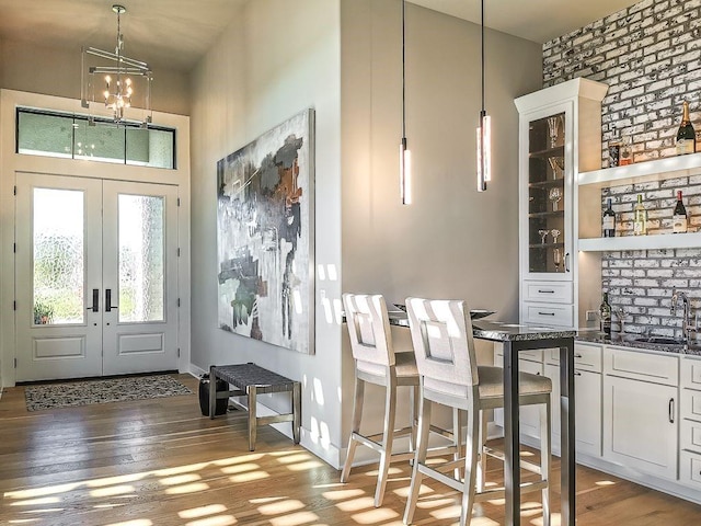 2908 NE 102nd St, Kansas City, MO 64155 - entrance foyer with dark wood-type flooring, an inviting chandelier, brick wall, sink, and french doors
