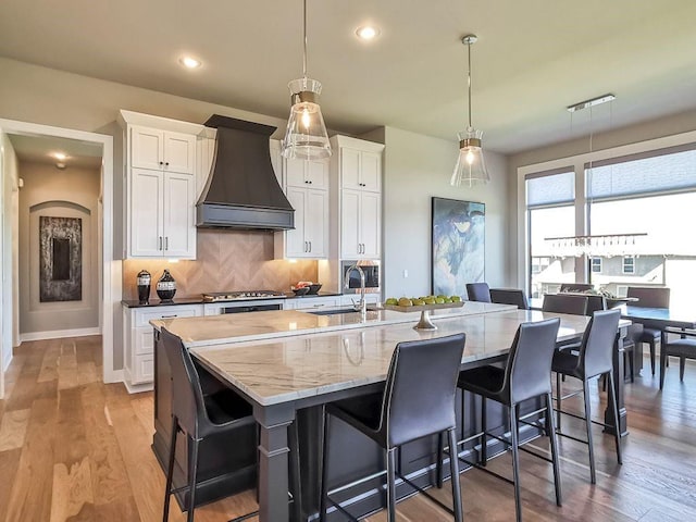 2908 NE 102nd St, Kansas City, MO 64155 - kitchen featuring backsplash, light hardwood / wood-style floors, custom exhaust hood, and sink