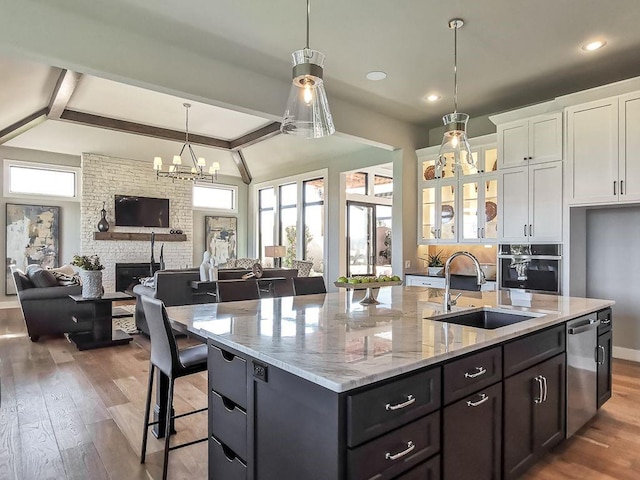 2908 NE 102nd St, Kansas City, MO 64155 - kitchen featuring oven, white cabinetry, hardwood / wood-style floors, a large fireplace, and sink