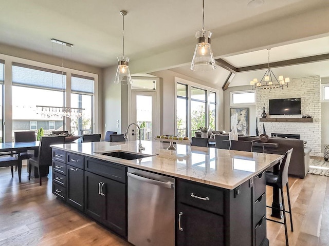 2908 NE 102nd St, Kansas City, MO 64155 - kitchen with an island with sink, stainless steel dishwasher, decorative light fixtures, and wood-type flooring
