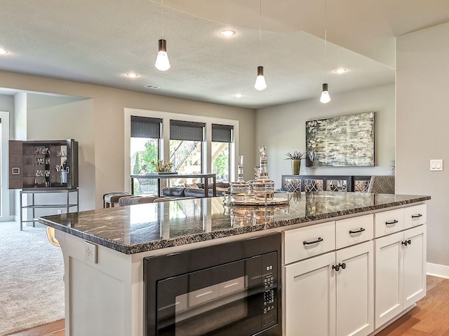 2908 NE 102nd St, Kansas City, MO 64155 - kitchen featuring light colored carpet, pendant lighting, dark stone counters, white cabinets, and black microwave