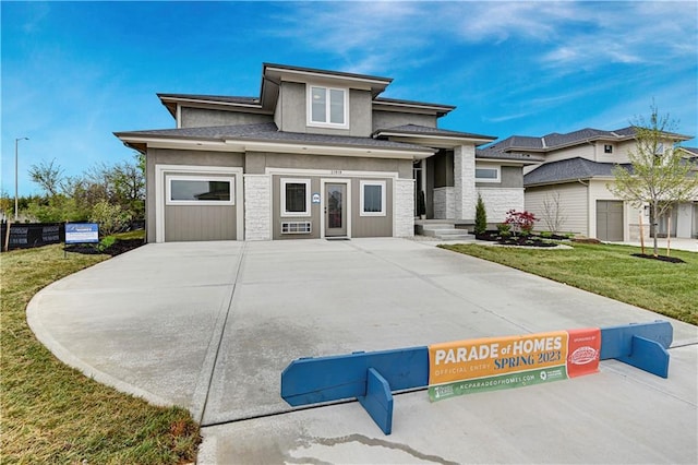 prairie-style home with a garage and a front yard