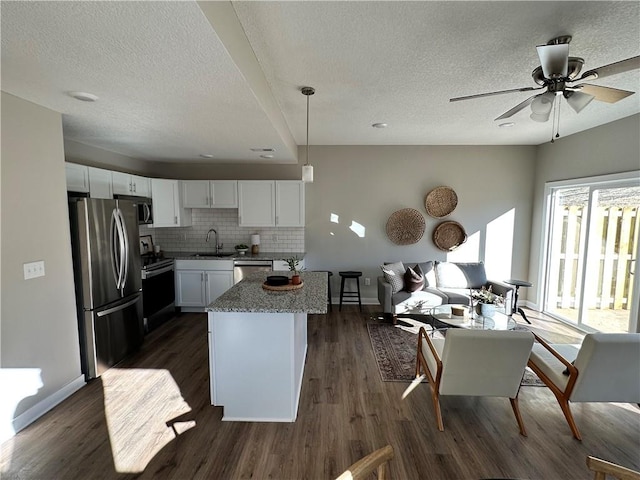 kitchen featuring tasteful backsplash, appliances with stainless steel finishes, dark hardwood / wood-style flooring, white cabinets, and sink