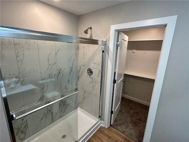 bathroom featuring an enclosed shower and wood-type flooring