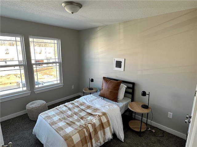 bedroom featuring dark carpet and a textured ceiling