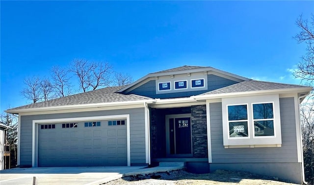 view of front of property with an attached garage, a shingled roof, and driveway