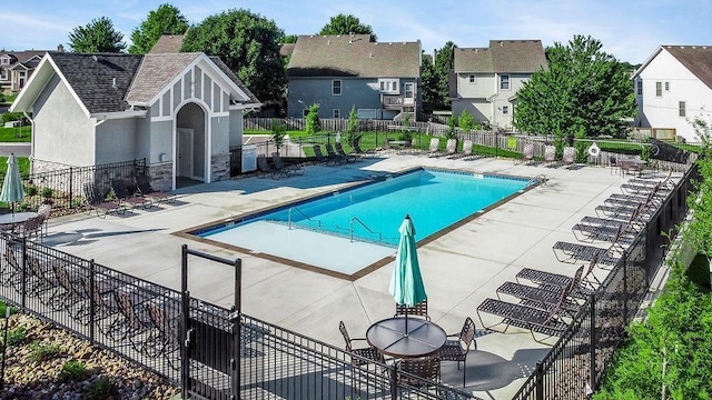 community pool featuring a residential view, a patio, and fence