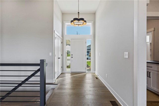 11606 S Zarda Dr, Olathe, KS 66061 - entryway with a chandelier, visible vents, baseboards, dark wood-type flooring, and a high ceiling