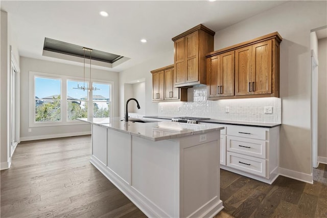 11606 S Zarda Dr, Olathe, KS 66061 - kitchen with baseboards, brown cabinets, decorative backsplash, and a sink