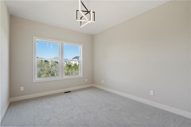 11606 S Zarda Dr, Olathe, KS 66061 - spare room featuring baseboards, visible vents, an inviting chandelier, and light colored carpet