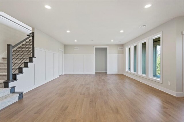 11606 S Zarda Dr, Olathe, KS 66061 - unfurnished living room with recessed lighting, stairs, a decorative wall, light wood finished floors, and visible vents