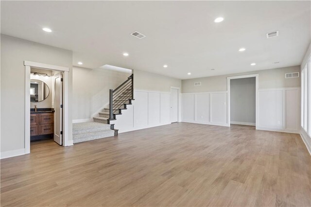 11606 S Zarda Dr, Olathe, KS 66061 - unfurnished living room with visible vents, light wood finished floors, and stairway