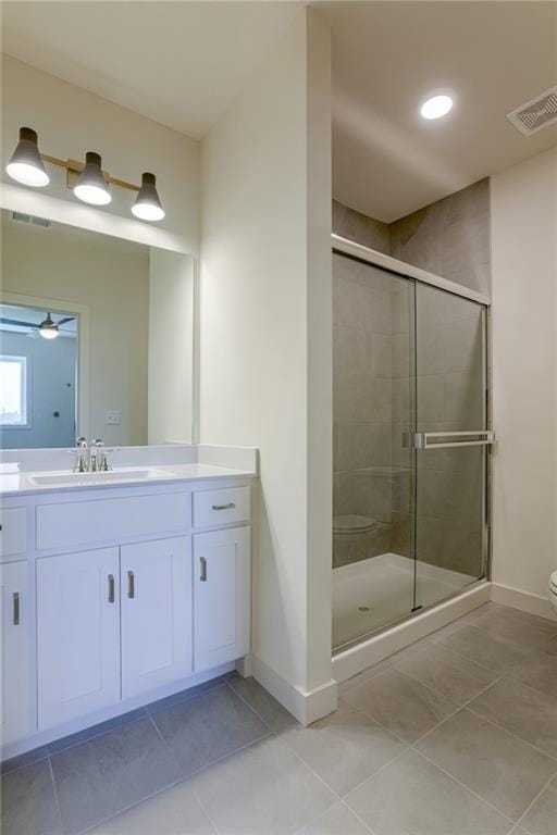 bathroom featuring toilet, a shower with shower door, vanity, ceiling fan, and tile floors