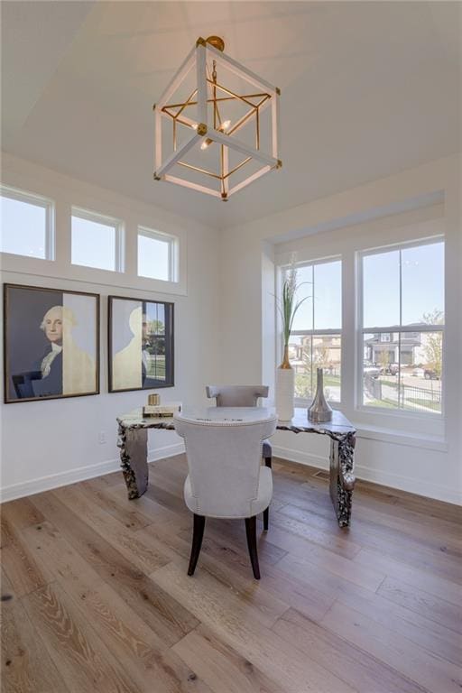 interior space featuring a high ceiling, a notable chandelier, and light hardwood / wood-style floors