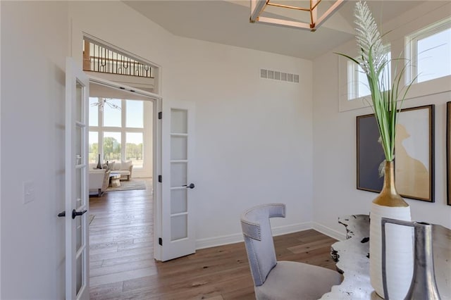 office area with a towering ceiling, hardwood / wood-style floors, and french doors