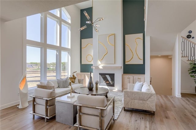 living room featuring a towering ceiling and light hardwood / wood-style flooring