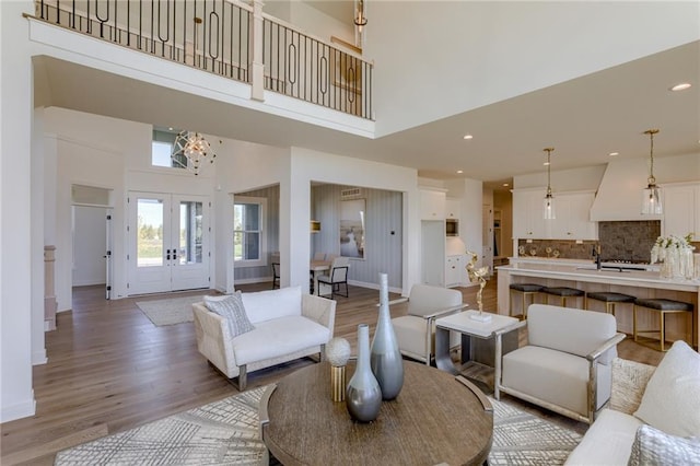 living room featuring hardwood / wood-style floors, a high ceiling, and french doors