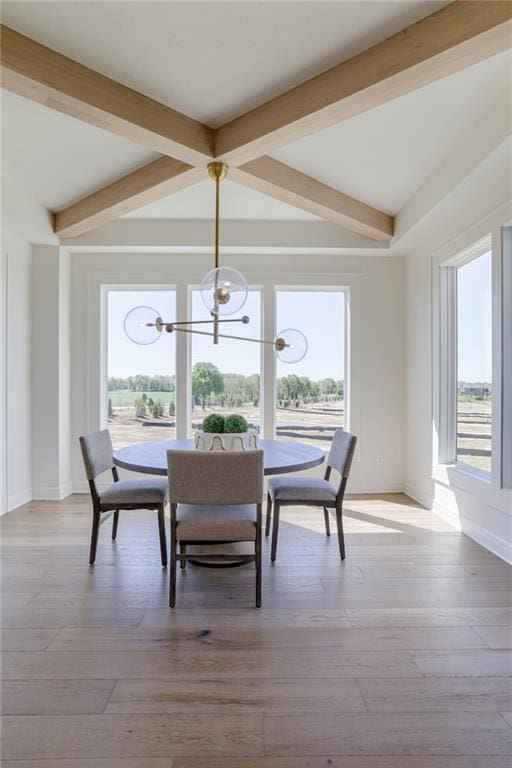 dining room with plenty of natural light, vaulted ceiling with beams, and light wood-type flooring