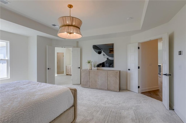 carpeted bedroom with a tray ceiling