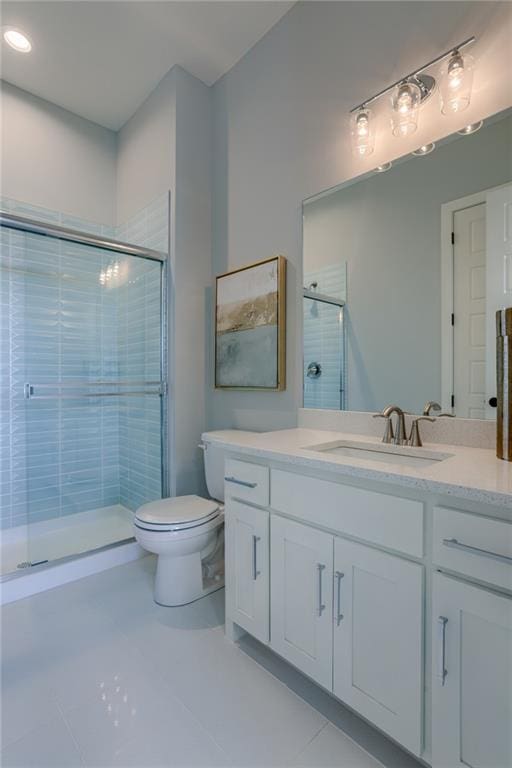 bathroom featuring oversized vanity, toilet, a shower with door, and tile flooring