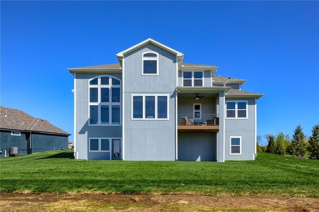 back of property with a balcony and a yard