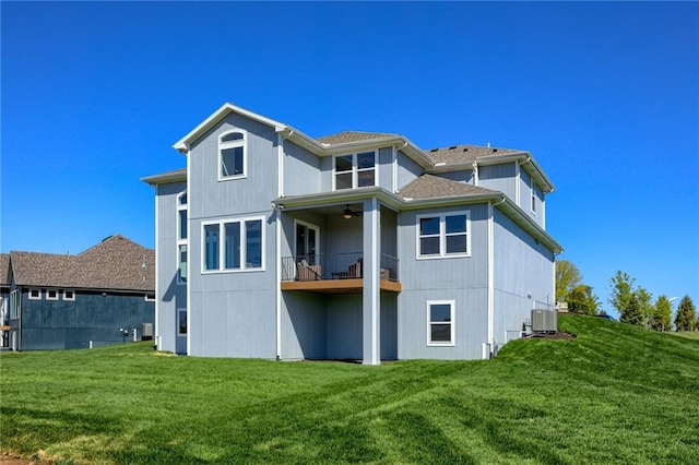 back of house featuring a yard, a balcony, and central air condition unit