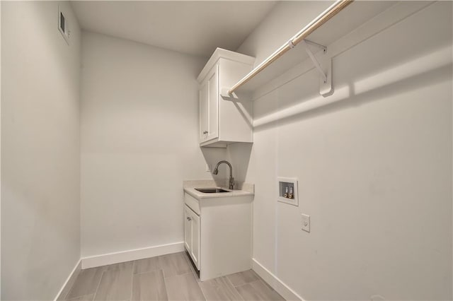 clothes washing area with washer hookup, cabinets, and sink