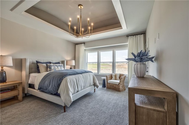 carpeted bedroom featuring a chandelier and a tray ceiling