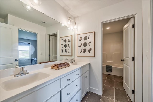 bathroom with tile floors, dual sinks, and vanity with extensive cabinet space