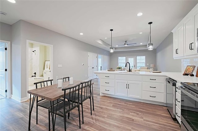 kitchen featuring kitchen peninsula, ceiling fan, hardwood / wood-style floors, white cabinetry, and sink