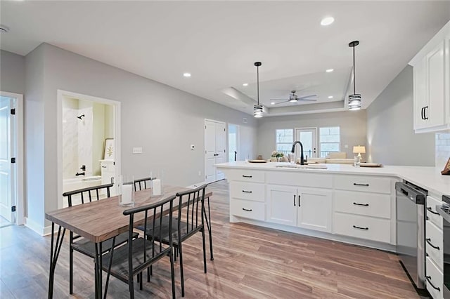 kitchen with decorative light fixtures, dishwasher, ceiling fan, hardwood / wood-style floors, and sink