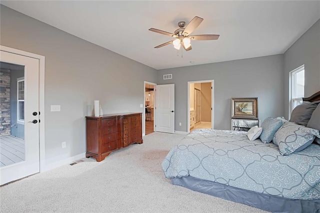 carpeted bedroom with connected bathroom, ceiling fan, and french doors