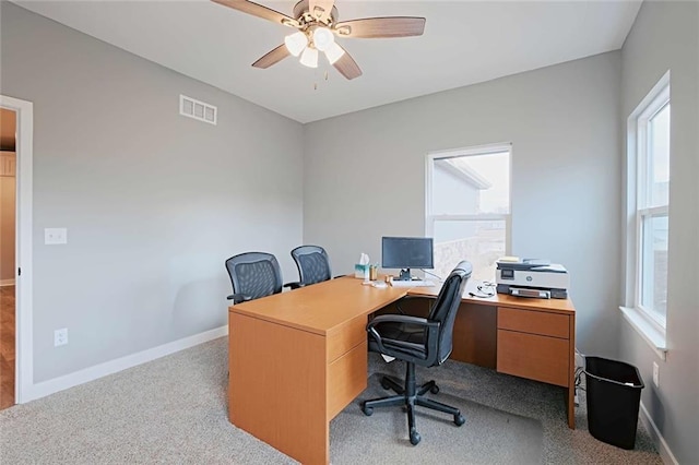 carpeted office with a wealth of natural light and ceiling fan