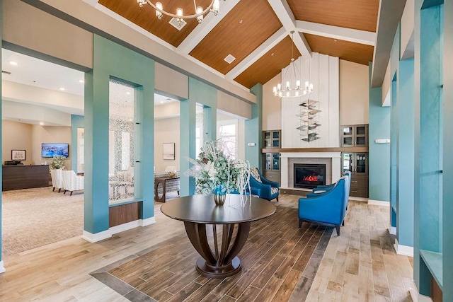 interior space with a notable chandelier, beam ceiling, wood ceiling, high vaulted ceiling, and wood-type flooring