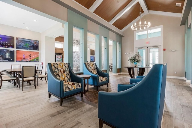 living room featuring high vaulted ceiling, french doors, hardwood / wood-style flooring, and a chandelier