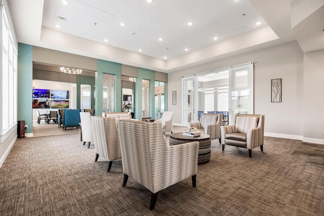 carpeted living room featuring a healthy amount of sunlight and a tray ceiling