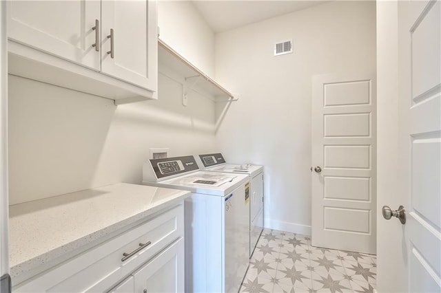 laundry room featuring independent washer and dryer and cabinets