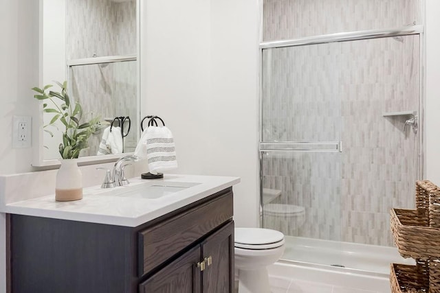 bathroom with an enclosed shower, toilet, tile patterned flooring, and vanity