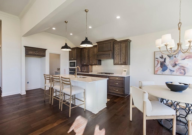 kitchen featuring decorative backsplash, stainless steel appliances, dark hardwood / wood-style floors, dark brown cabinets, and decorative light fixtures