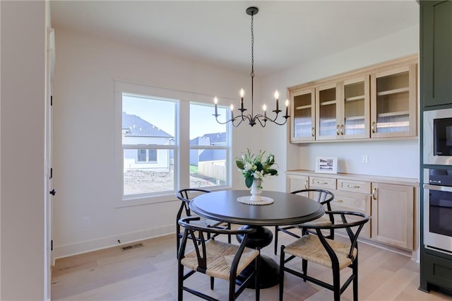 dining room with an inviting chandelier and light hardwood / wood-style flooring