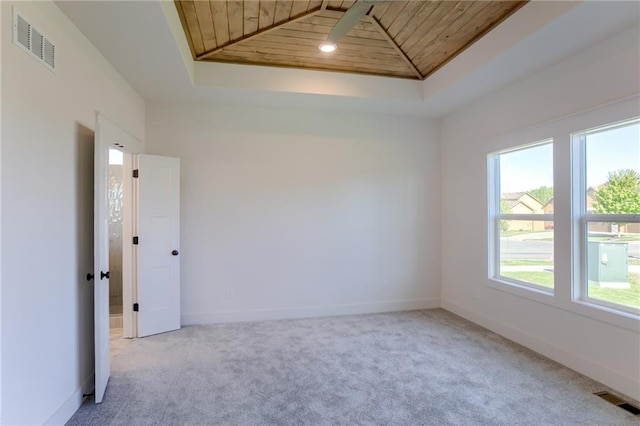 carpeted spare room featuring a raised ceiling, plenty of natural light, wooden ceiling, and lofted ceiling