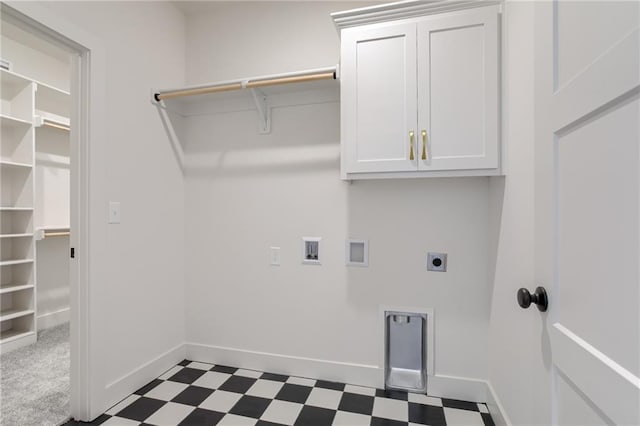 laundry area with hookup for an electric dryer, hookup for a washing machine, and cabinets